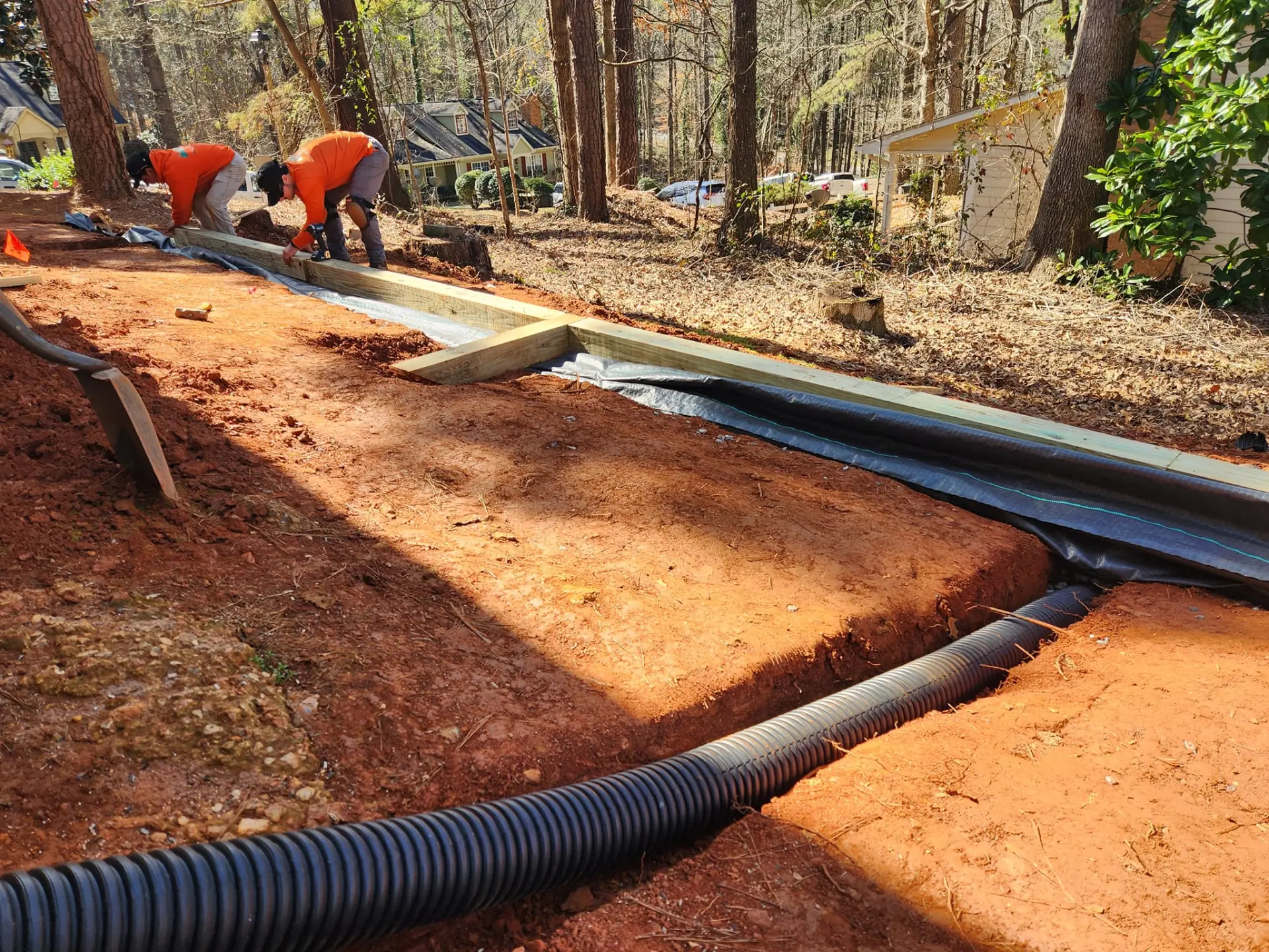 Perforated drainage pipe installed behind a timber retaining wall